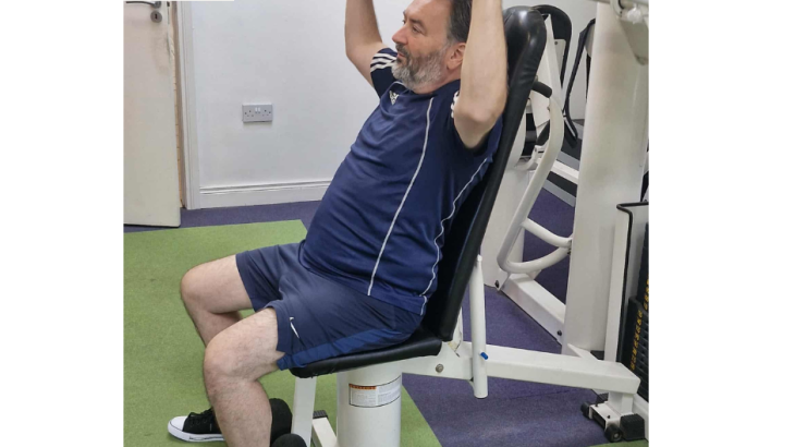 Alan training at Lifegym using a strength machine during his 6-week body transformation program.